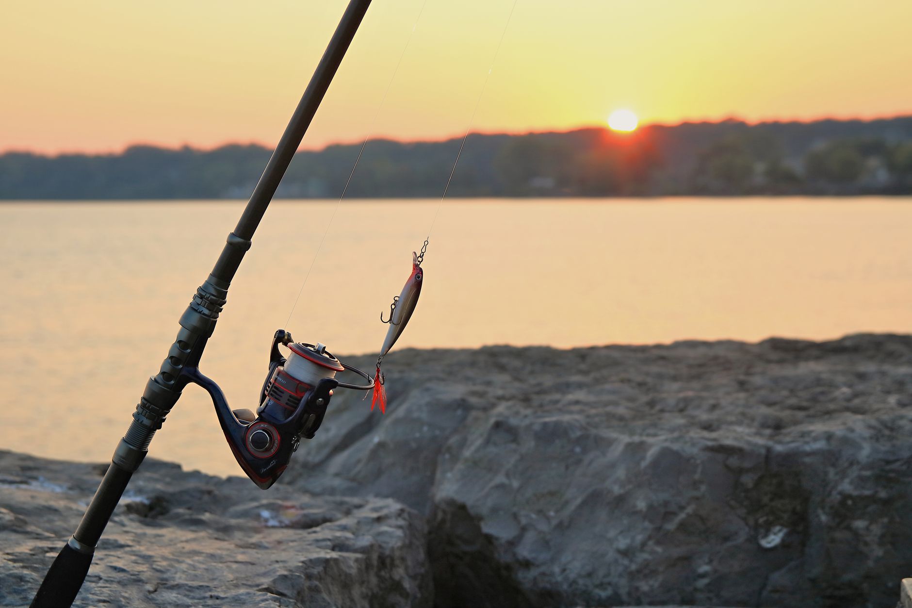 Fishing rod and lure at sunrise on a rocky pier in Webster Lake, NY. — Lucky Seven Casino: Die Bedeutung der Spielerbewertung
